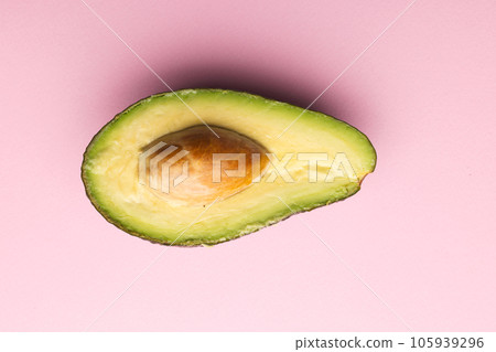 Close up of half of avocado and copy space on pink background 105939296