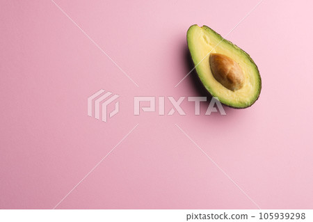 Close up of half of avocado and copy space on pink background 105939298