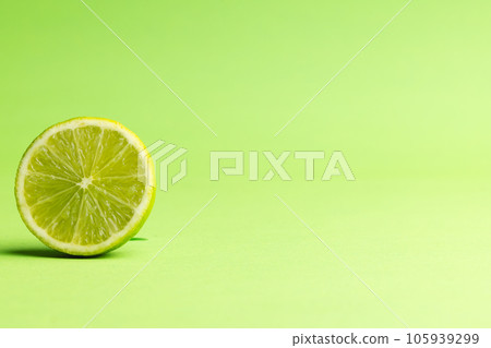 Close up of halved lime and copy space on green background Close up of halved lime and copy space on green background 105939299