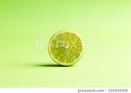 Close up of halved lime and copy space on green background Close up of halved lime and copy space on green background 105939300