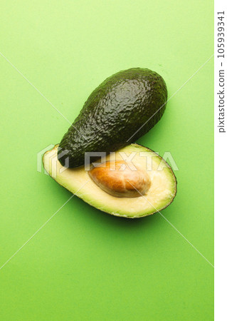 Close up of two halves of avocado and copy space on green background 105939341