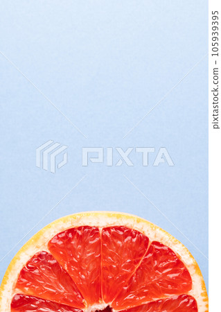 Close up of half of red grapefruit and copy space on blue background 105939395