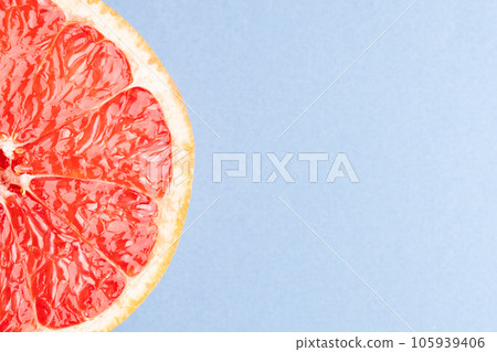Close up of half of red grapefruit and copy space on blue background 105939406