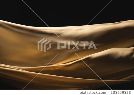 Close up of gold shiny silk fabric with copy space on black background 105939528