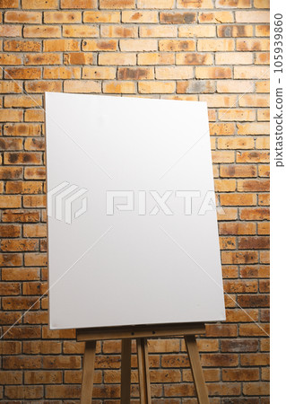 White canvas on wooden easel and copy space on brick wall background 105939860