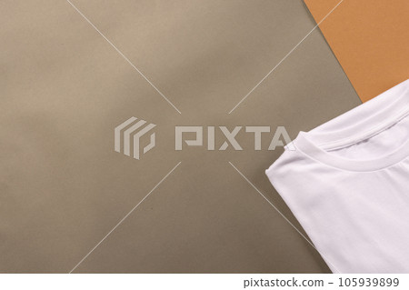 Close up of folded white t shirts and copy space on brown background Close up of folded white t shirts and copy space on brown background 105939899