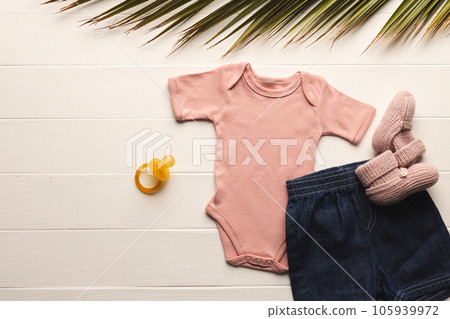 Flat lay of pink baby grow, shorts, dummy and pink booties with copy space on white background Flat lay of pink baby grow, shorts, dummy and pink booties with copy space on white background 105939972