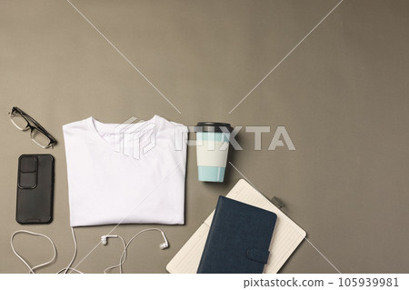 Flat lay of white t shirt, smartphone, earphones and notebooks with copy space on grey background 105939981