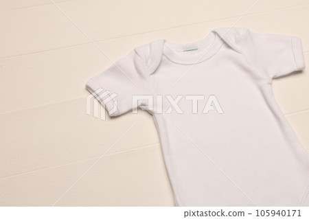 Flat lay of white baby grow with copy space on white board background Flat lay of white baby grow with copy space on white board background 105940171