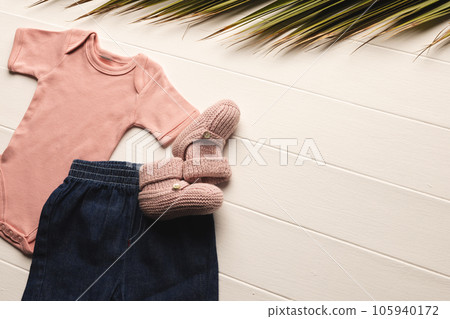 Flat lay of pink baby grow, shorts and pink booties with copy space on white background Flat lay of pink baby grow, shorts and pink booties with copy space on white background 105940172
