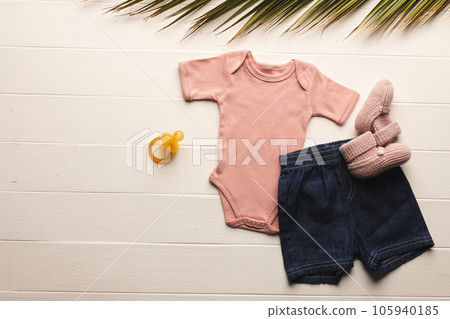 Flat lay of pink baby grow, shorts, dummy and pink booties with copy space on white background Flat lay of pink baby grow, shorts, dummy and pink booties with copy space on white background 105940185