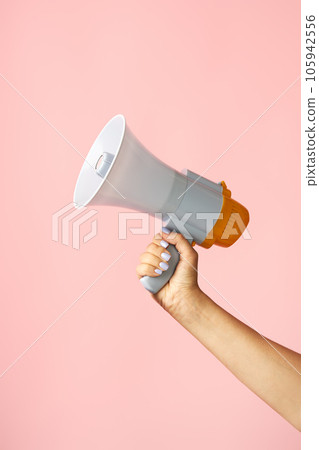 Megaphone loudspeaker in woman hands on pink background 105942556