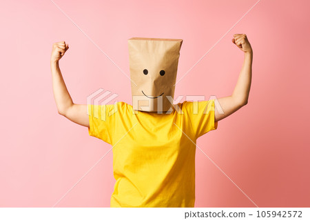 Happy woman with paper bag over head show biceps muscles proud of achievements and personal success 105942572