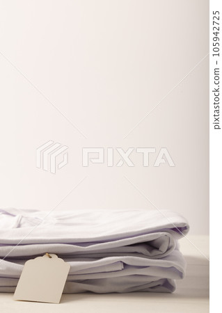 Stack of white t shirts with tag and copy space on white background Stack of white t shirts with tag and copy space on white background 105942725