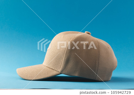 Cream baseball cap and copy space on blue background Cream baseball cap and copy space on blue background 105942729