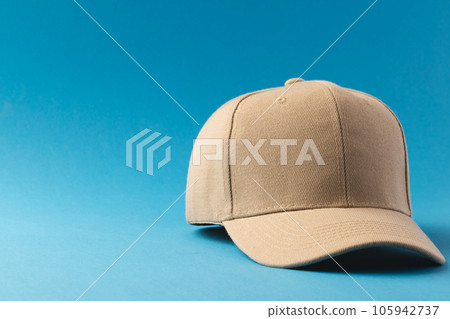 Cream baseball cap and copy space on blue background 105942737