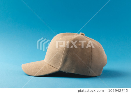 Cream baseball cap and copy space on blue background 105942745