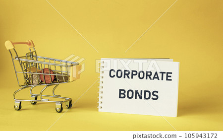 Notepad with the text Corporate bonds on a yellow background. Toy cart with coins Notepad with the text Corporate bonds on a yellow background. Toy cart with coins 105943172