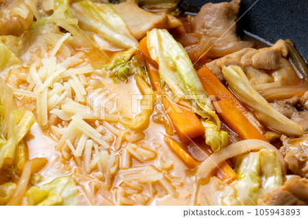 A close-up of the cooking scene of making cheese dak galbi (Korean-style stir-fried chicken and vegetables with cheese) in a frying pan. 105943893