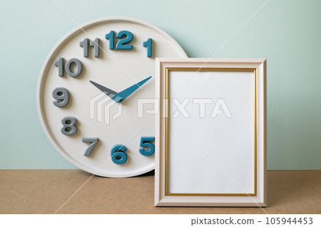 Blank picture frame with clock on brown shelf. mint wall background. copy space 105944453