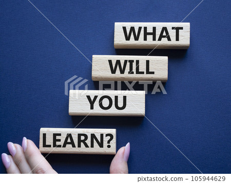 What will you learn symbol. Concept word. What will you learn on wooden blocks. Beautiful deep blue background. Businessman hand. Business and What will you learn concept. Copy space 105944629