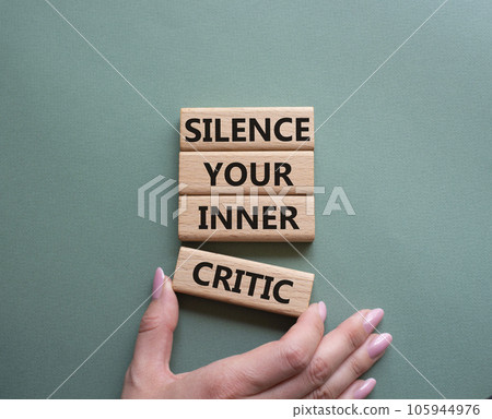 Silence your inner critic symbol. Wooden blocks with words Silence your inner critic. Beautiful grey green background. Businessman hand. Business and Silence your inner critic concept. Copy space. 105944976