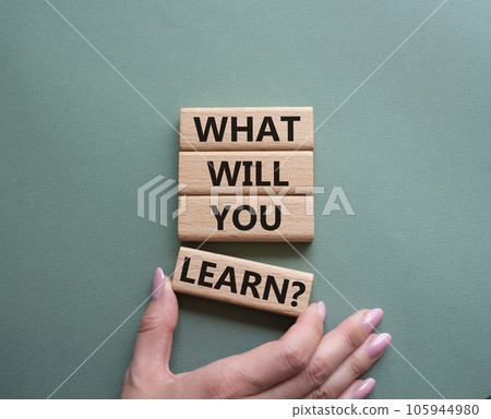 What will you learn symbol. Concept word. What will you learn on wooden blocks. Beautiful grey green background. Businessman hand. Business and What will you learn concept. Copy space 105944980