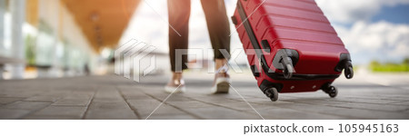 Woman walking with suitcase to the airport. 105945163