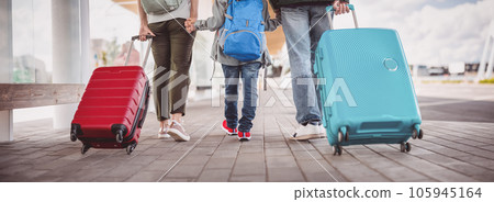 Mother, father and their son walking with suitcase to the airport. Mother, father and their son walking with suitcase to the airport. 105945164