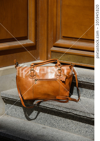 orange female leather bag. street photo 105945820