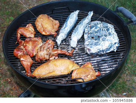 Chicken parts and corn on a barbeque grill 105945886