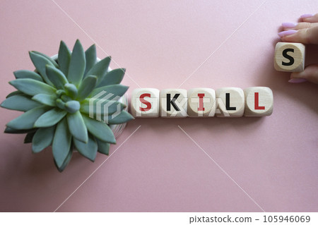 Skills symbol. Concept word Skills on wooden cubes. Businessman hand. Beautiful pink background with succulent plant. Business and Skills concept. Copy space. Skills symbol. Concept word Skills on wooden cubes. Businessman hand. Beautiful pink background with succulent plant. Business and Skills concept. Copy space. 105946069