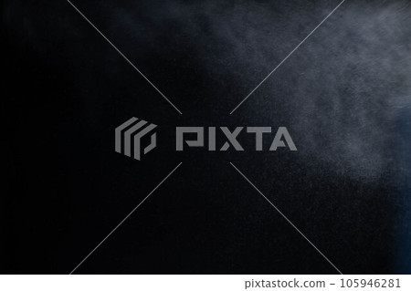 Water spray dust on dark background. Spraying mist effect isolated on black background. Water spray dust on dark background. Spraying mist effect isolated on black background. 105946281