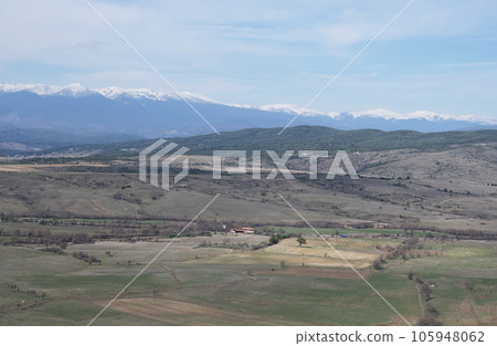 Panoramic view of the green fields of western Bulgaria and the house in the center of the photo on a summer day. Panoramic view of the green fields of western Bulgaria and the house in the center of the photo on a summer day. 105948062