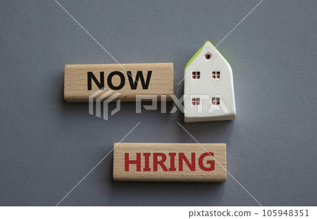 Now Hiring symbol. Concept word Now Hiring on wooden blocks. Beautiful grey background. Business and Now Hiring concept. Copy space 105948351