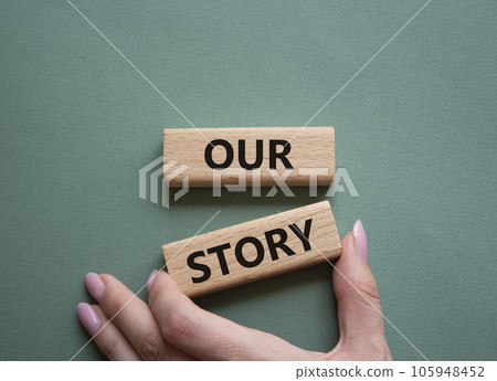 Our story symbol. Wooden blocks with words Our story Beautiful grey green background. Businessman hand. Business and Our story concept. Copy space. Our story symbol. Wooden blocks with words Our story Beautiful grey green background. Businessman hand. Business and Our story concept. Copy space. 105948452