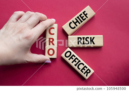 CRO - Chief Risk Officer symbol. Concept word CRO on wooden cubes. Businessman hand. Beautiful red background. Business and CRO concept. Copy space. 105948500