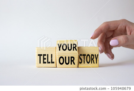 Tell Your or Our story symbol. Businessman hand points at wooden cubes with words Tell Our story and Tell Your story. Beautiful white background. Business concept. Copy space 105948679