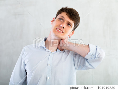 Young guy holding his sore neck Young guy holding his sore neck 105949880