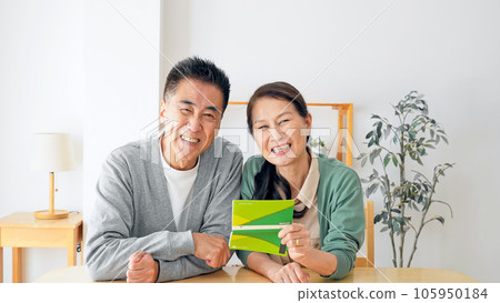 Senior couple laughing with a bankbook 105950184