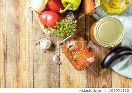 Healthy homemade fermented food. Salad with aubergines and vegetables on a rustic table. Home economics, autumn harvest preservation. View from above. Copy space. 105951180
