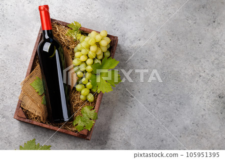 A red wine bottle and fresh grapes 105951395