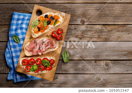 Sandwich set of bruschetta with juicy tomatoes, cheese and prosciutto 105951547