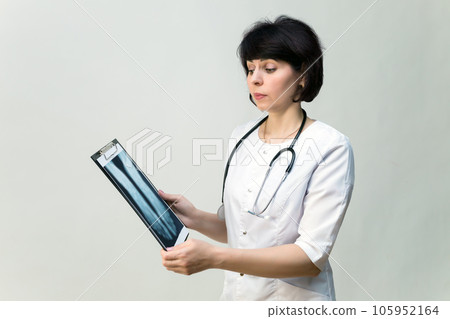 Female nurse examines a picture of a broken leg Female nurse examines a picture of a broken leg 105952164