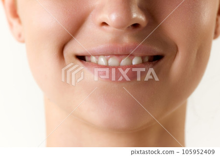 Cropped image of female face over white background. Teeth whitening, mouth hygiene and treatment Cropped image of female face over white background. Teeth whitening, mouth hygiene and treatment 105952409