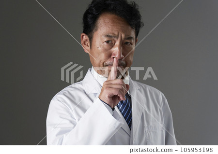 Middle-aged doctor doing a secret pose Black background Middle-aged doctor doing a secret pose Black background 105953198