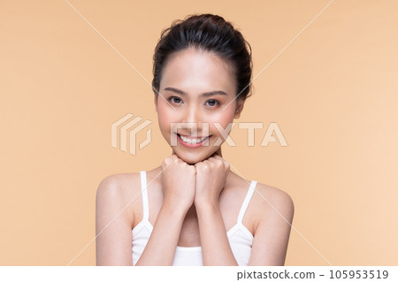 Beautiful Asian young woman touching soft cheek smile with clean fresh skin Happiness and cheerful with positive emotional,isolated on Beige background,Beauty Cosmetics and Facial treatment Concept 105953519