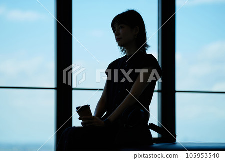 Silhouette of a young woman looking at the view from an observatory 105953540