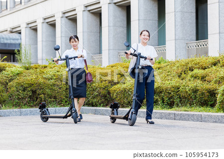 Business woman commuting with an electric kickboard Business woman commuting with an electric kickboard 105954173