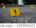 A group of yellow crime scene evidence markers on the street after a gun shooting brass bullet shell casing rifle 105954223